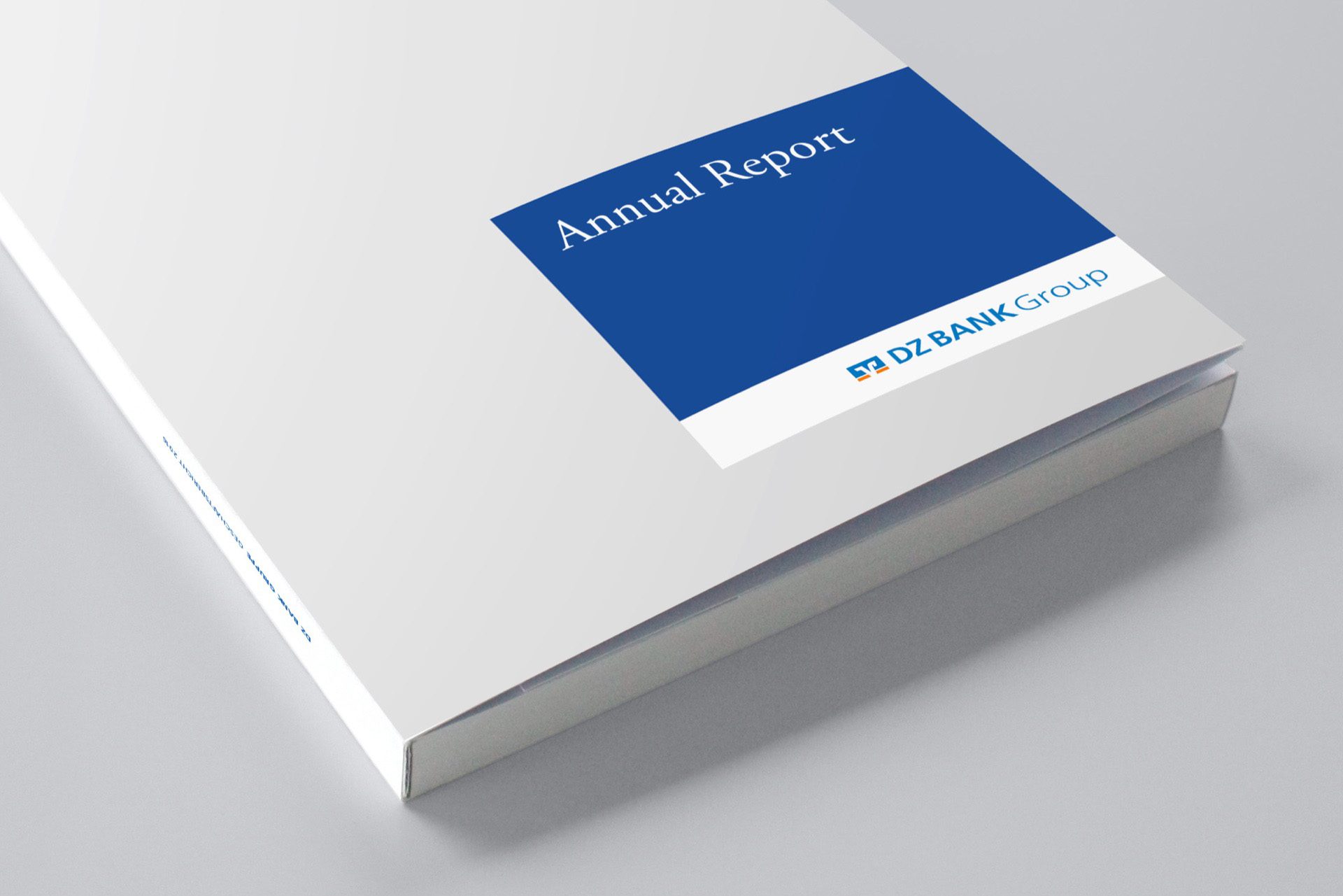 The image shows a sleek and professional-looking book titled "Annual Report." It appears to be published by "XYZ Bank Group," as indicated by the name on the cover. The cover is minimalistic, featuring a simple layout with a dominant blue rectangular section at the top and white space surrounding it. The book is likely an annual report created by a bank or financial institution to summarize its yearly financial performance, key activities, and strategic initiatives. Such reports usually include financial statements, management discussions, and analyses geared towards investors, stakeholders, and regulatory bodies.