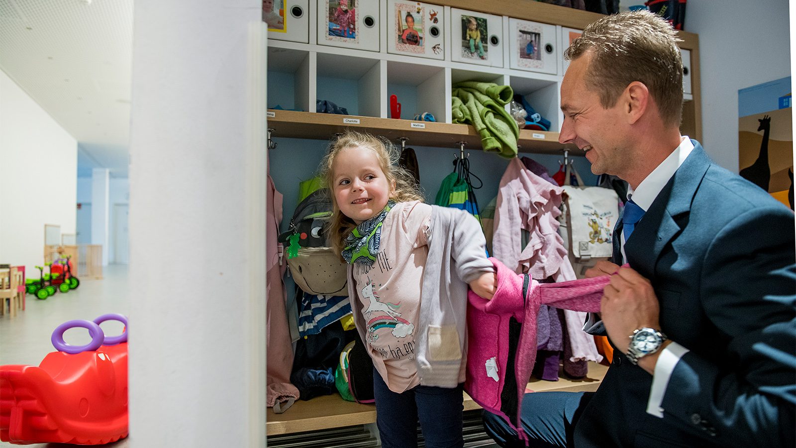 Vater mit Tochter in KiTa Garderobe