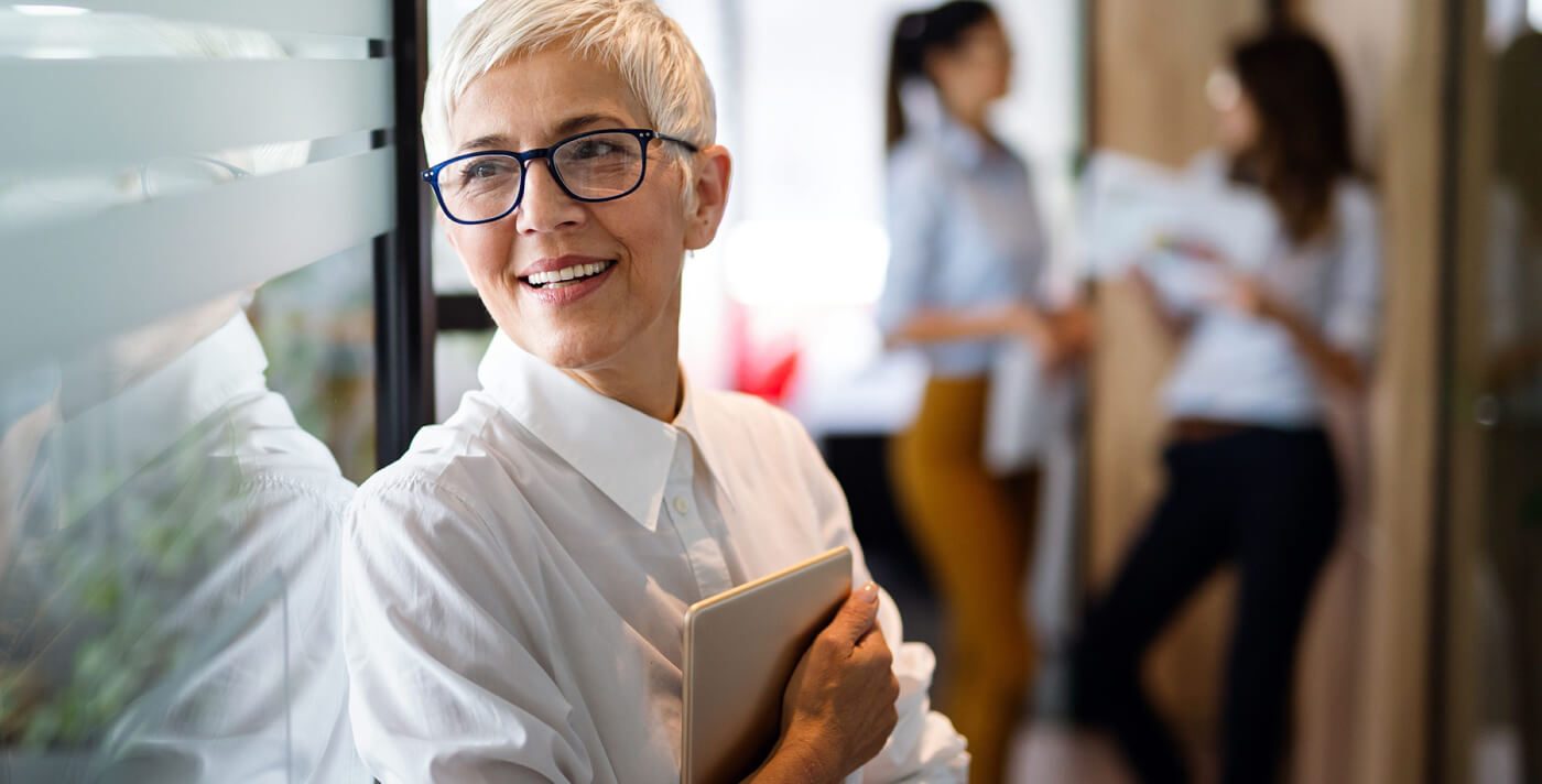 A woman in business attire and with a tablet computer in her hand