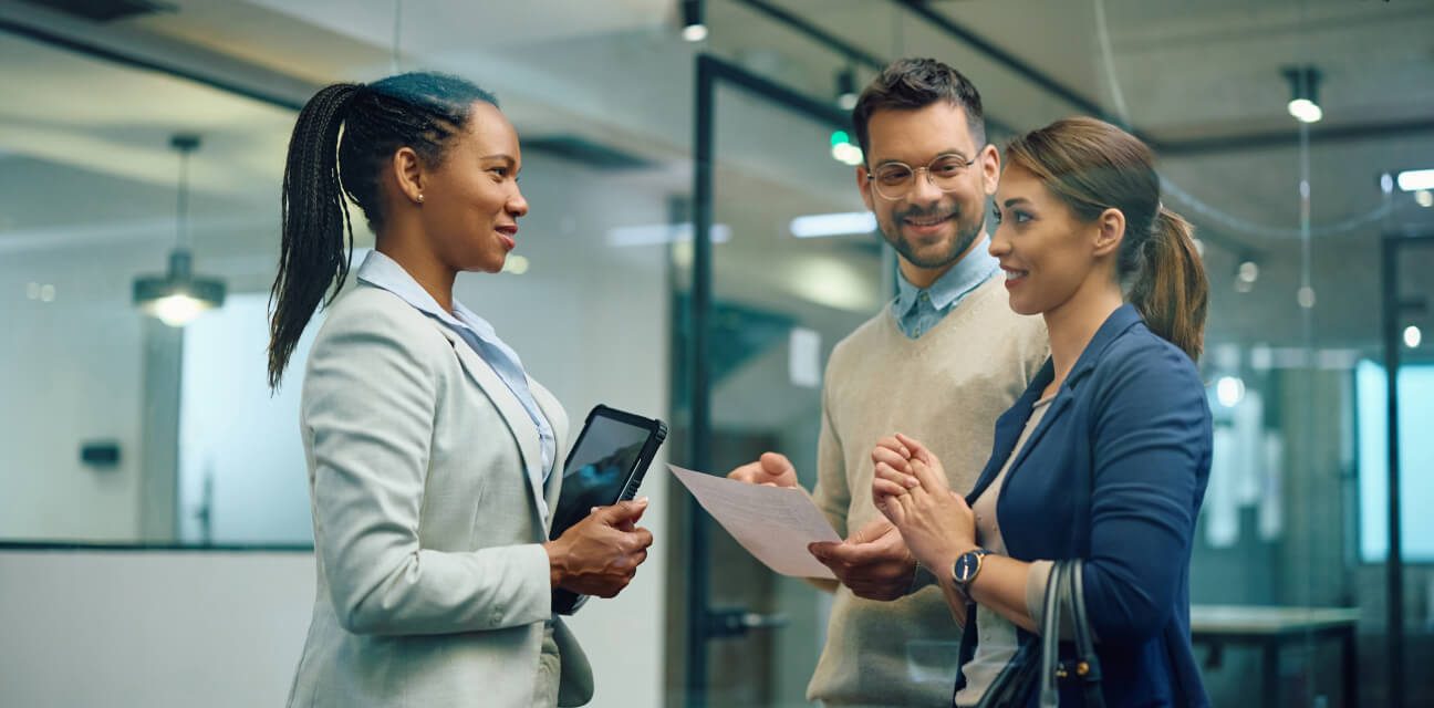 Three people in business attire lively discussing a topic