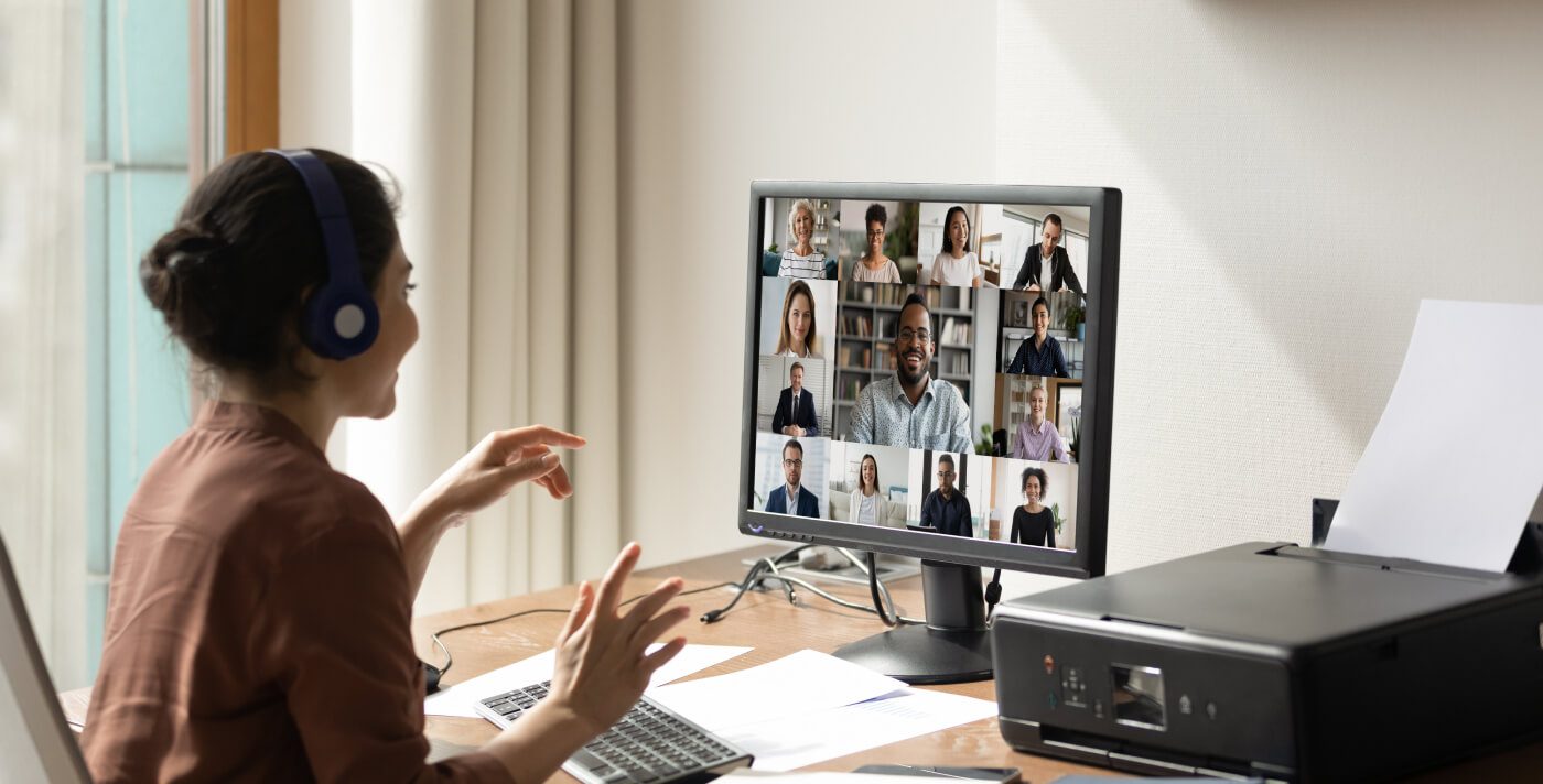 A day in the life of research experts: a woman  takes part in an online meeting, on her computer  screen a diverse group of people from different  cultural backgrounds