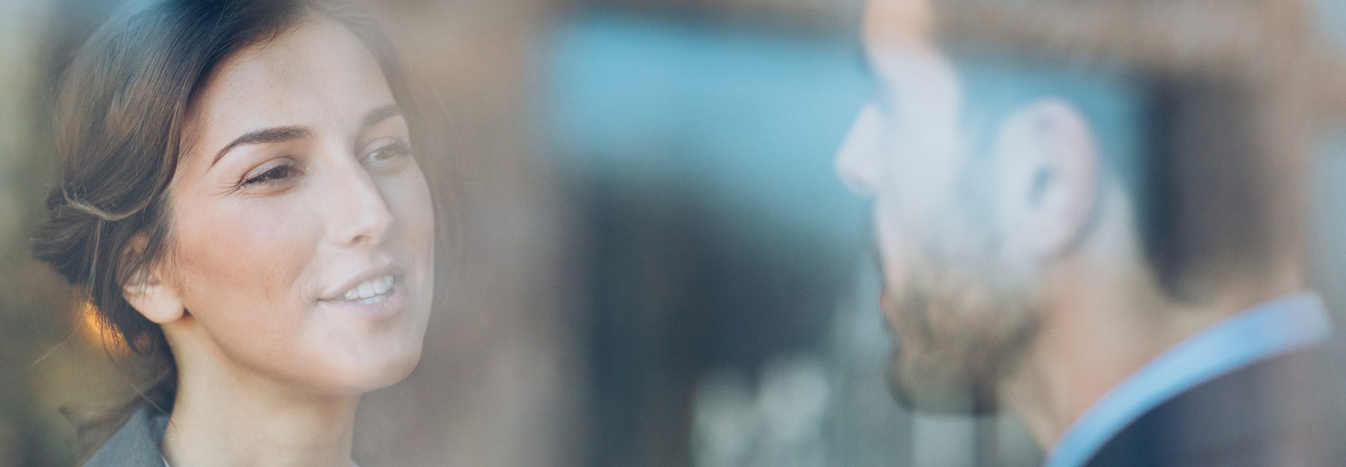 Two Individuals Appearing in a Blurred Background