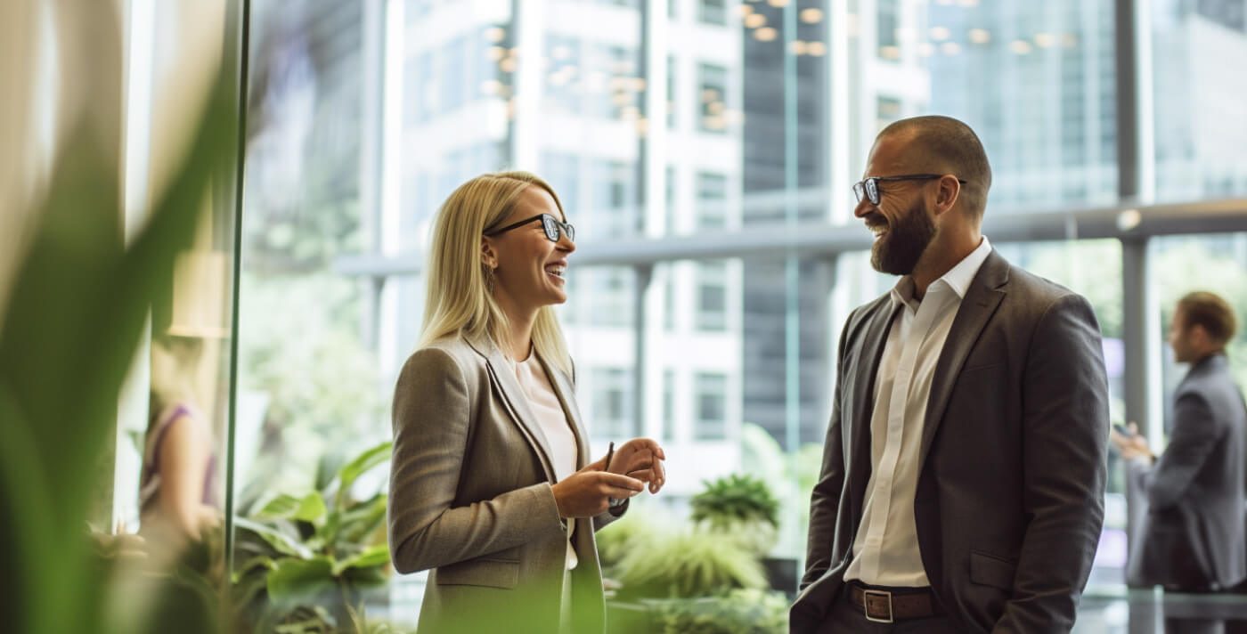 Two colleagues are having a casual and good-humored chat in business surroundings