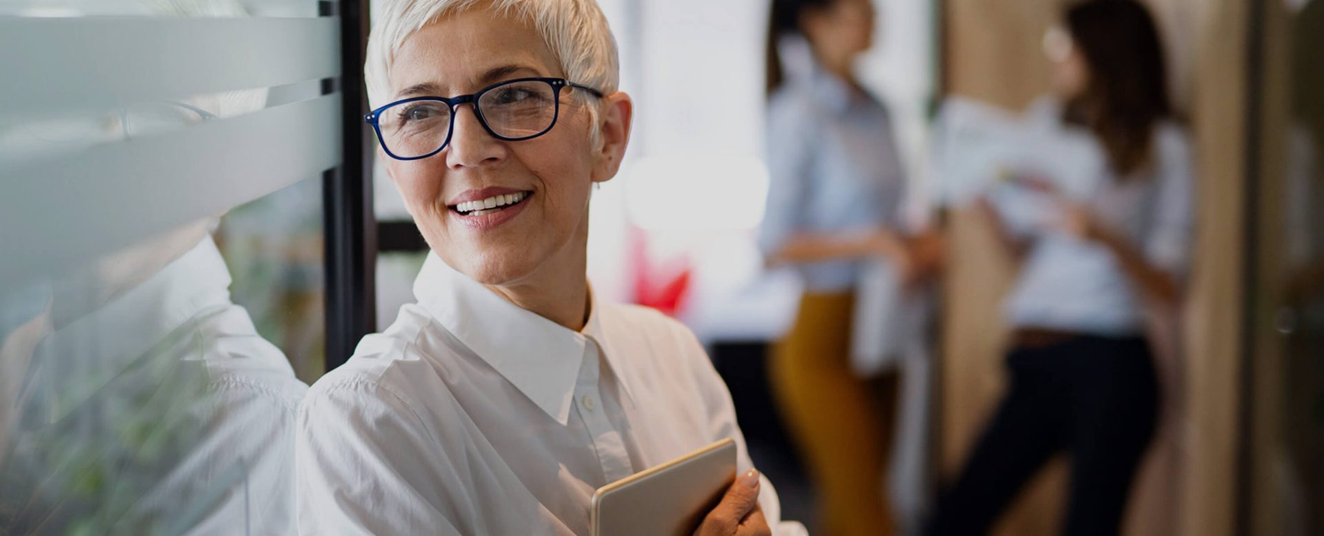 A woman in business attire and a tablet computer in her hand welcomes you to the DZ BANK international network page